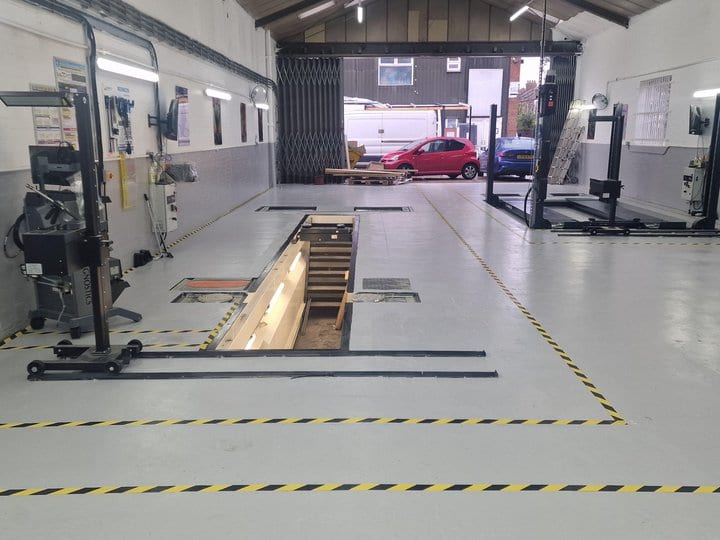 Inspection pit in a pit-based MOT bay, with a vehicle over the pit