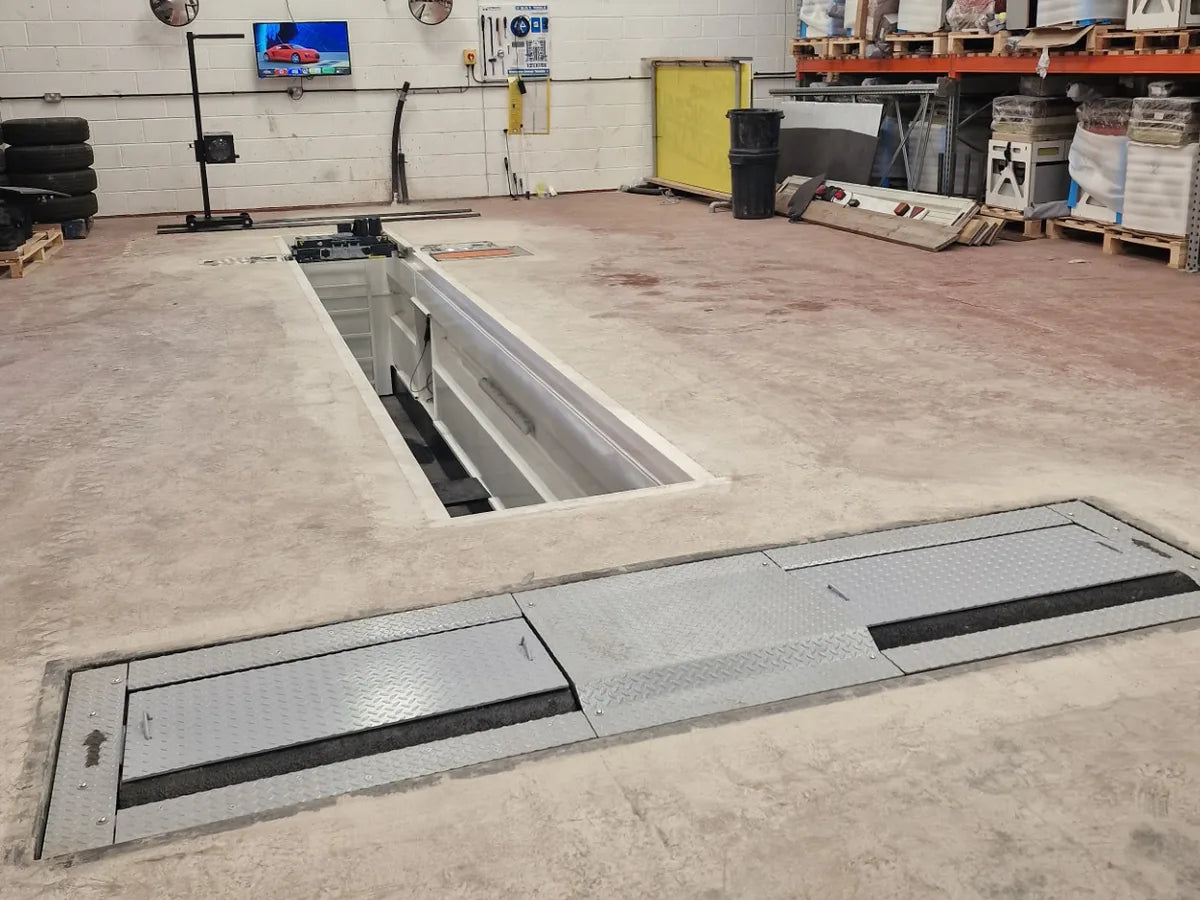 A pit-based MOT bay installed by Liftmaster, with the inspection pit, vehicle and test equipment